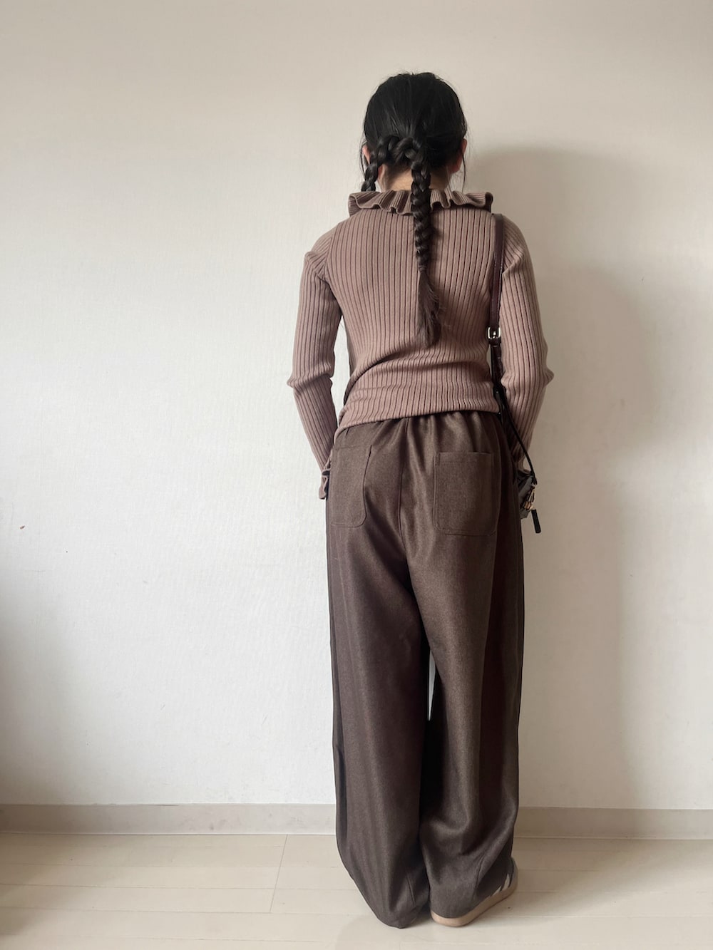 ホワイト系のニット/セーター、ブラウン系のその他パンツ、ブラウン系のハンドバッグを着用したキッズの冬コーディネートの5枚目の写真