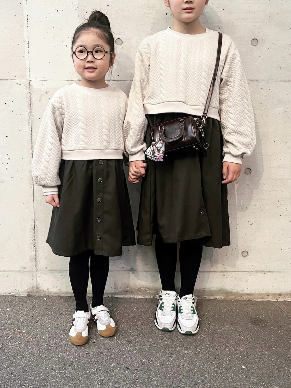 ベージュ系のワンピース、ベージュ系のワンピース、グリーン系のスニーカーを着用したキッズの冬コーディネートの3枚目の写真