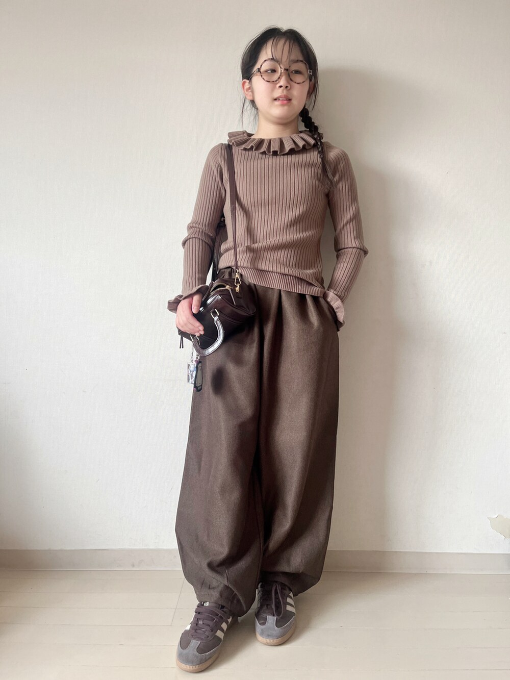 ホワイト系のニット/セーター、ブラウン系のその他パンツ、ブラウン系のハンドバッグを着用したキッズの冬コーディネートの4枚目の写真