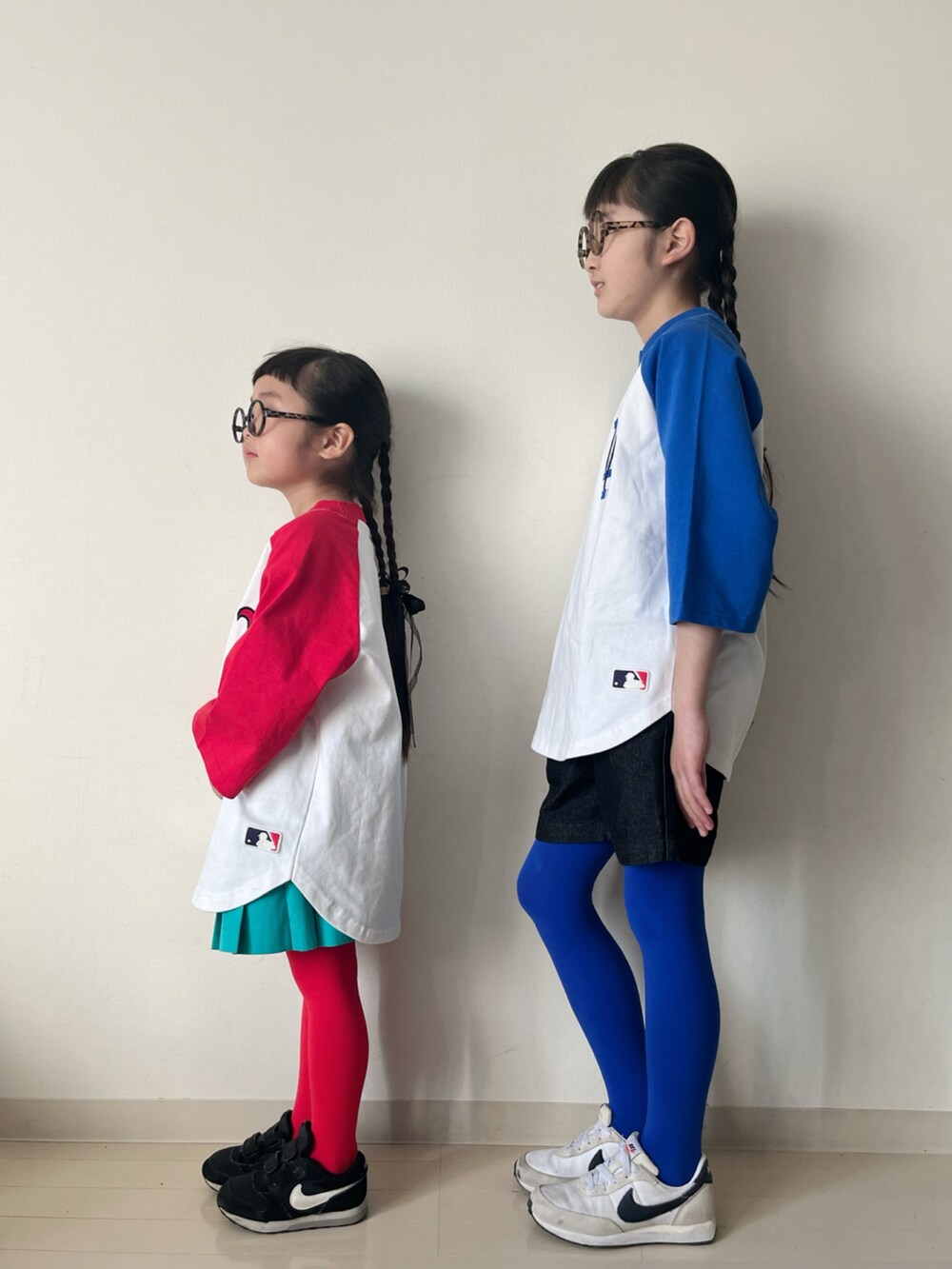 レッド系のTシャツ/カットソー、グリーン系のスカート、ブラック系のデニムパンツを着用したキッズの冬コーディネートの2枚目の写真