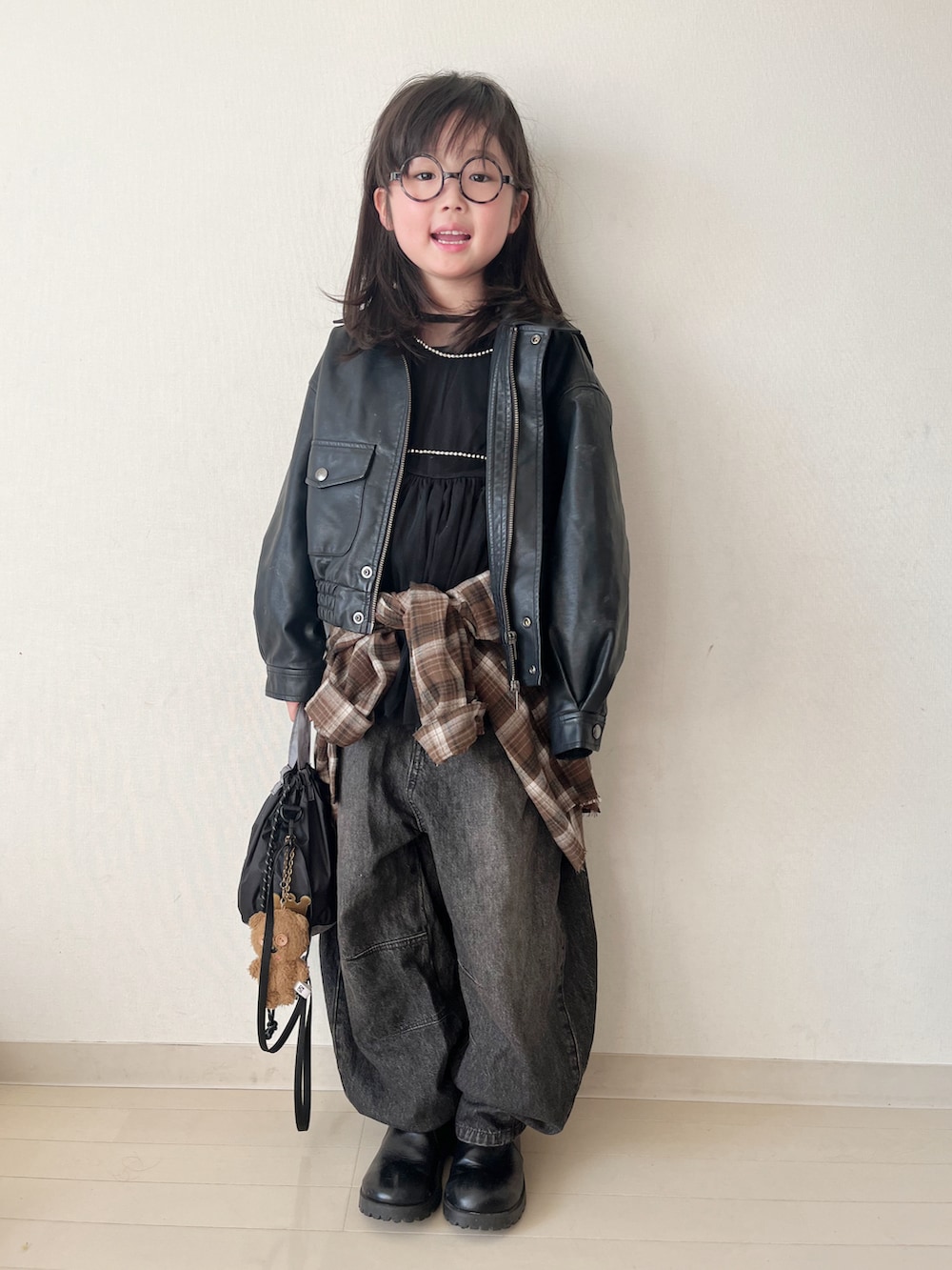 ブラウン系のトップス、ブラック系のデニムパンツ、ブラック系のタンクトップを着用したキッズの冬コーディネートの2枚目の写真
