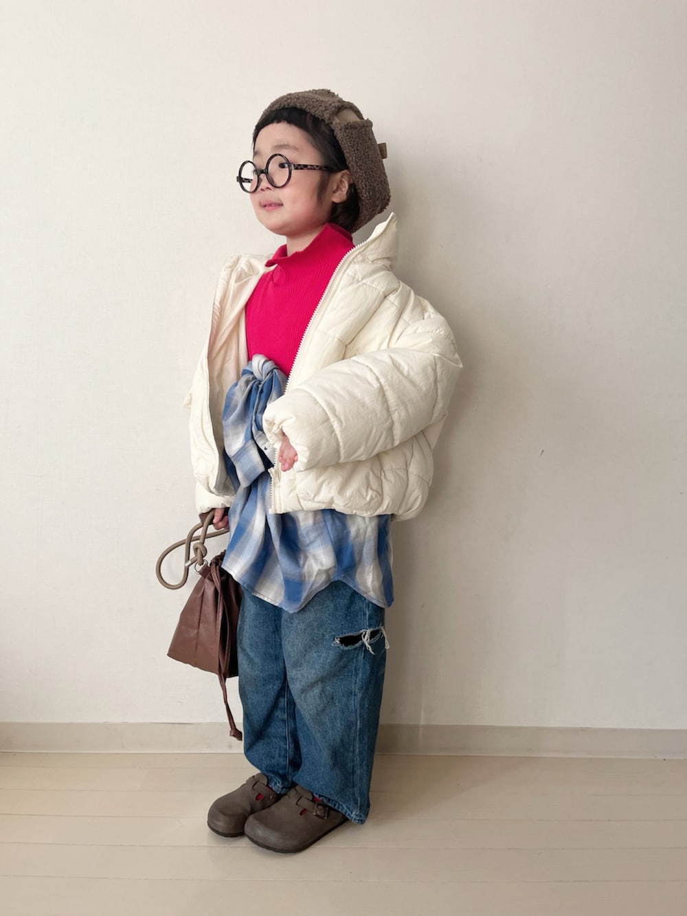 ホワイト系のダウンジャケット/コート、レッド系のTシャツ/カットソー、ブルー系のデニムパンツを着用したキッズの冬コーディネートの3枚目の写真