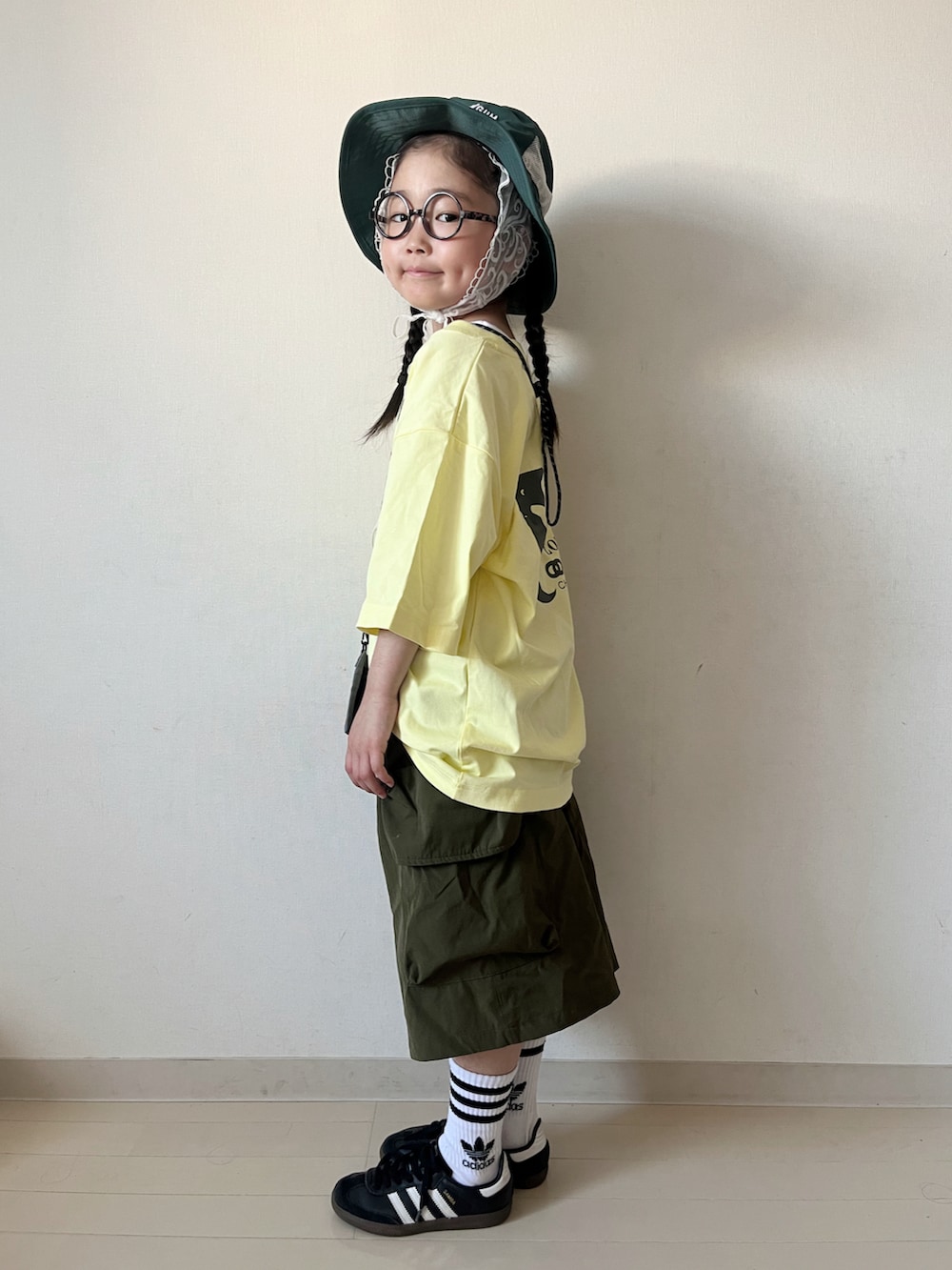 イエロー系のTシャツ/カットソー、グリーン系のカーゴパンツ、ブラック系のスニーカーを着用したキッズの夏コーディネートの4枚目の写真