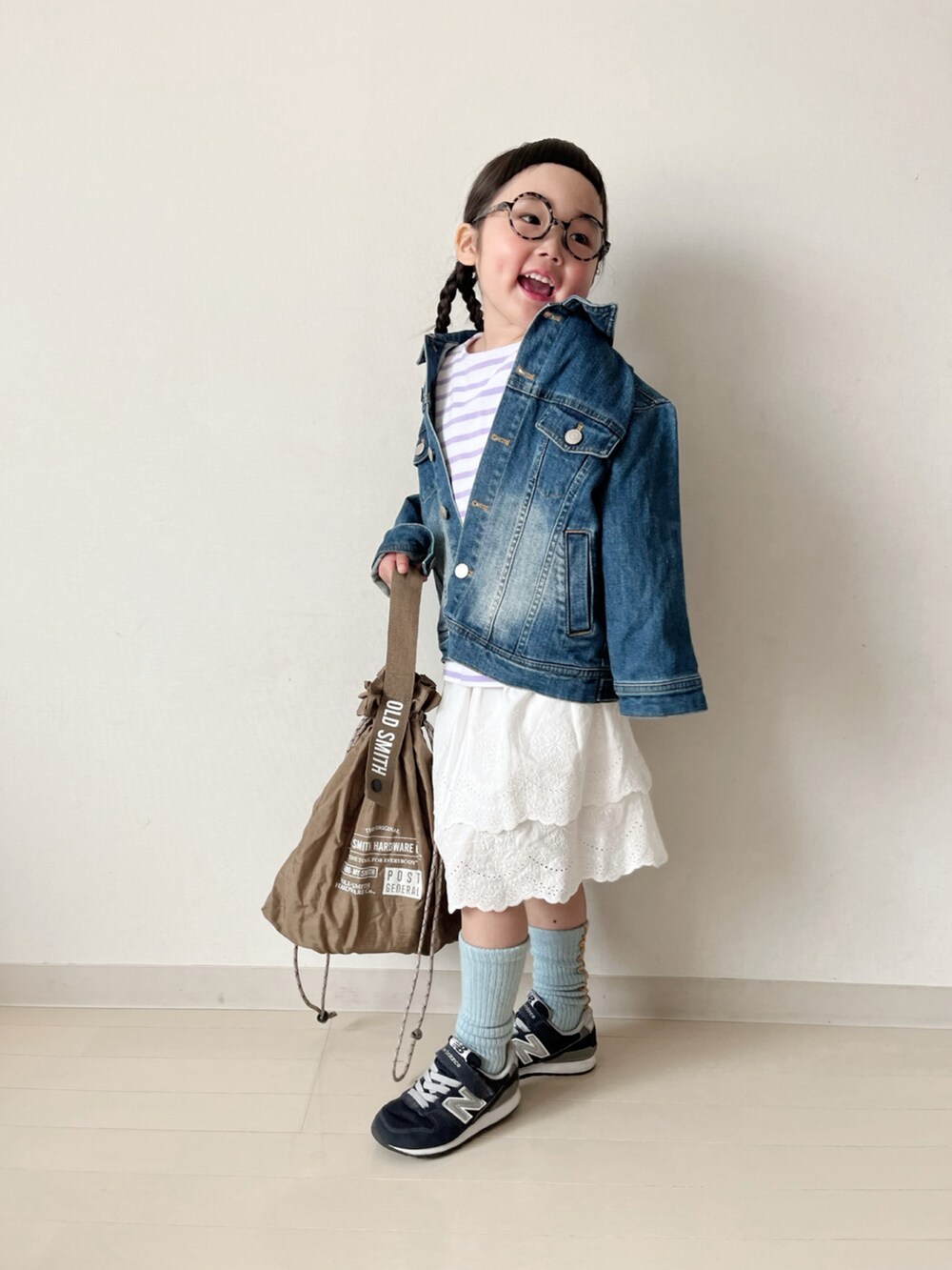 パープル系のTシャツ/カットソー、ホワイト系のスカート、ブルー系のデニムジャケットを着用したキッズの春コーディネートの2枚目の写真