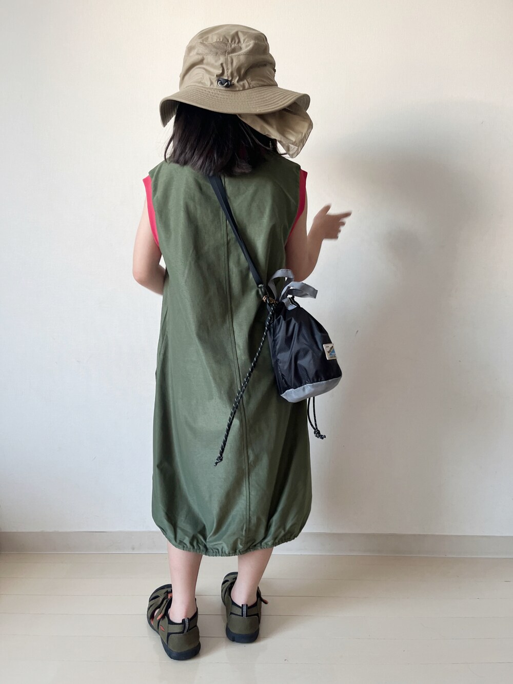 グリーン系のワンピース、ブラック系のショルダーバッグ、グリーン系のサンダルを着用したキッズの夏コーディネートの5枚目の写真