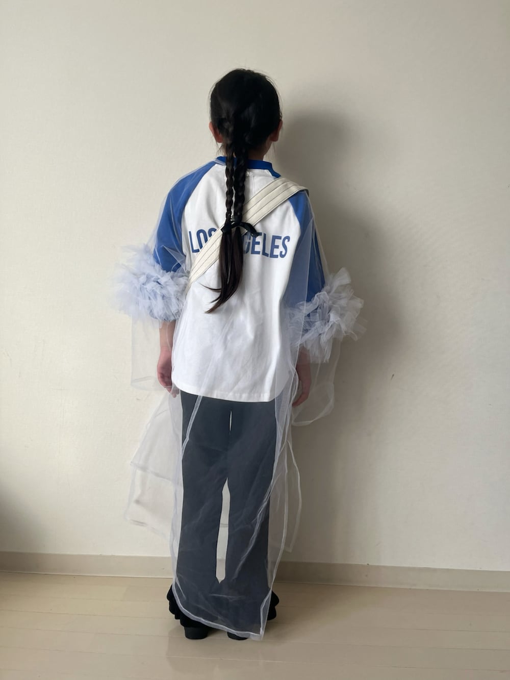 ブルー系のTシャツ/カットソー、ホワイト系のワンピース、ホワイト系のショルダーバッグを着用したキッズの春コーディネートの3枚目の写真