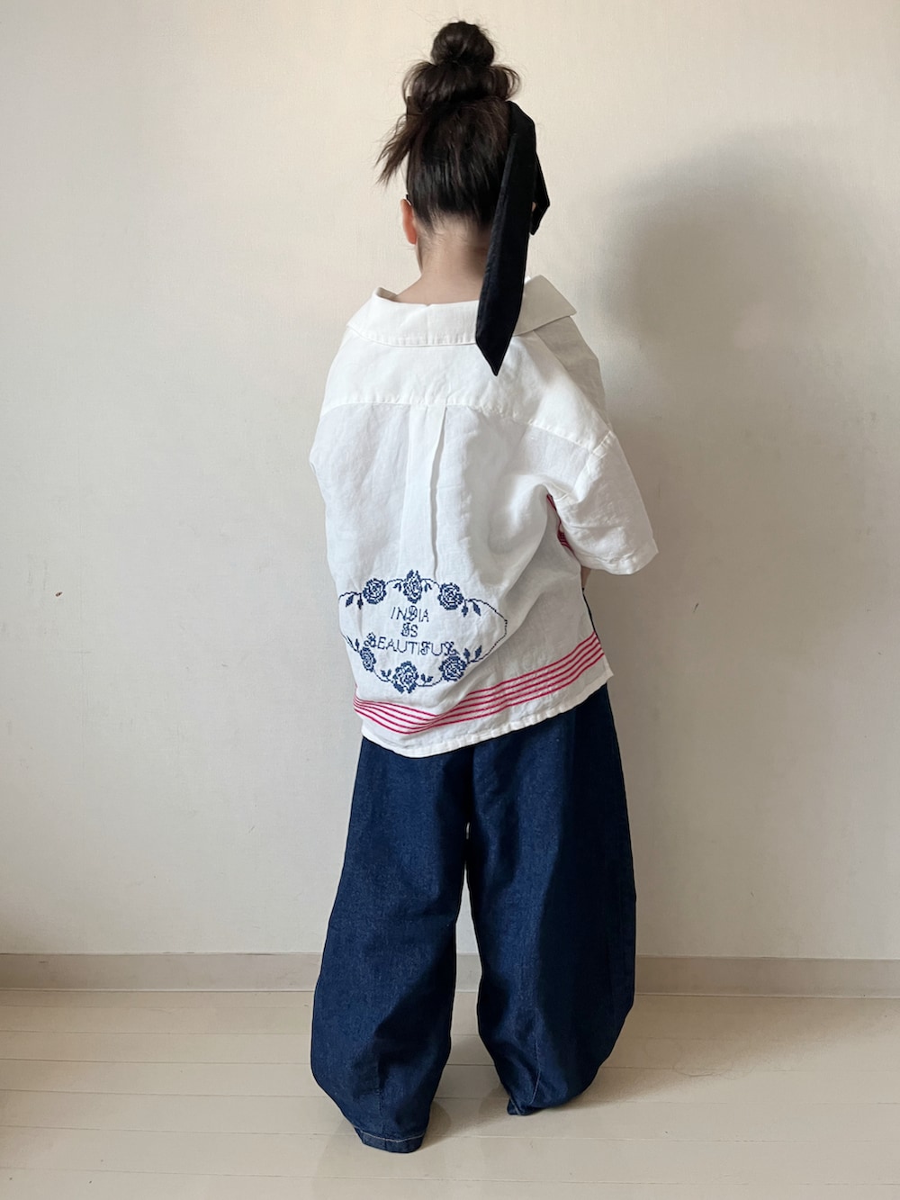 ホワイト系のシャツ/ブラウス、ブルー系のデニムパンツ、レッド系のスニーカーを着用したキッズの春コーディネートの5枚目の写真