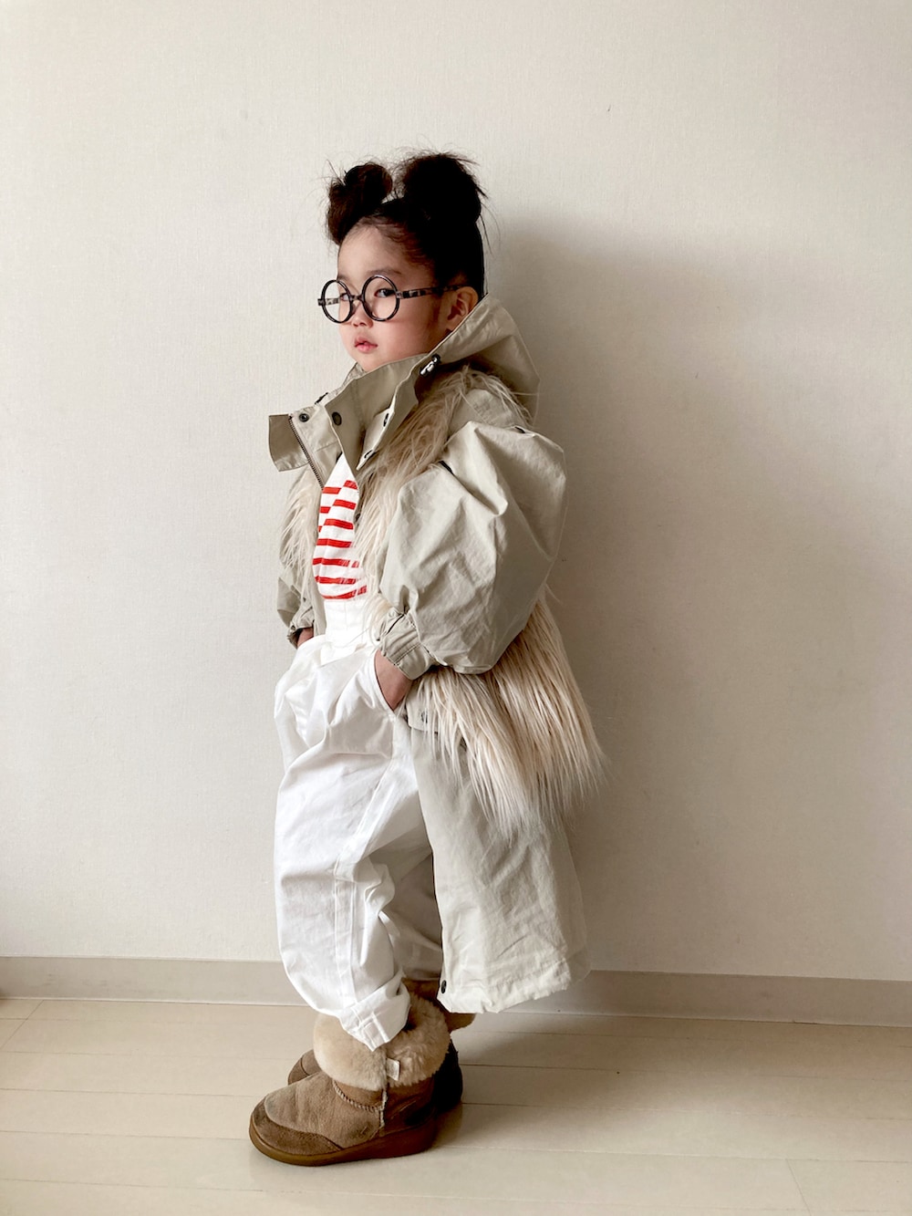ベージュ系のモッズコート、ホワイト系のベスト、ホワイト系のその他パンツを着用したキッズの冬コーディネートの2枚目の写真