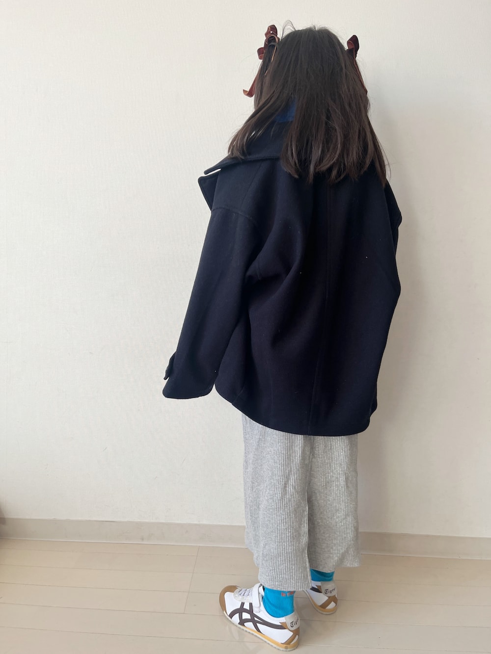 グレー系のカーディガン/ボレロ、ブルー系のピーコート、グレー系のスカートを着用したキッズの秋コーディネートの3枚目の写真