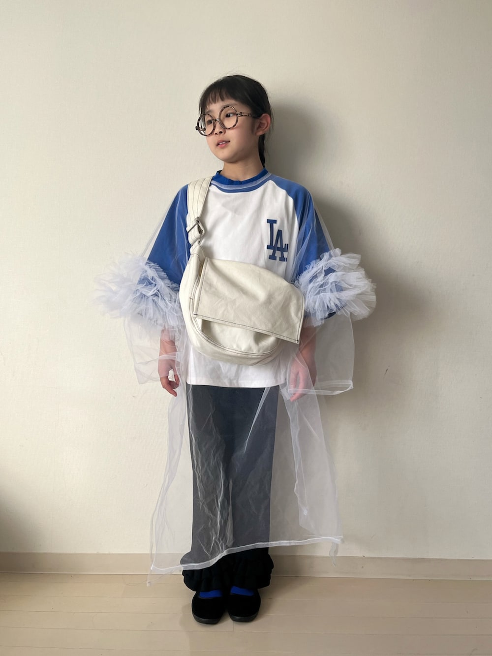 ブルー系のTシャツ/カットソー、ホワイト系のワンピース、ホワイト系のショルダーバッグを着用したキッズの春コーディネートの2枚目の写真