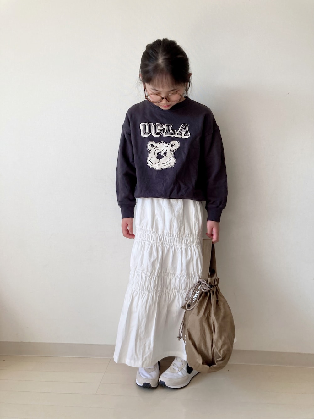 ホワイト系のスカート、グレー系のスウェット、ベージュ系のエコバッグ/サブバッグを着用したキッズの春コーディネートの5枚目の写真