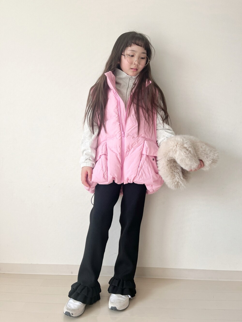 ブラック系のその他パンツ、ピンク系のダウンベスト、ベージュ系のスウェットを着用したキッズの冬コーディネートの5枚目の写真