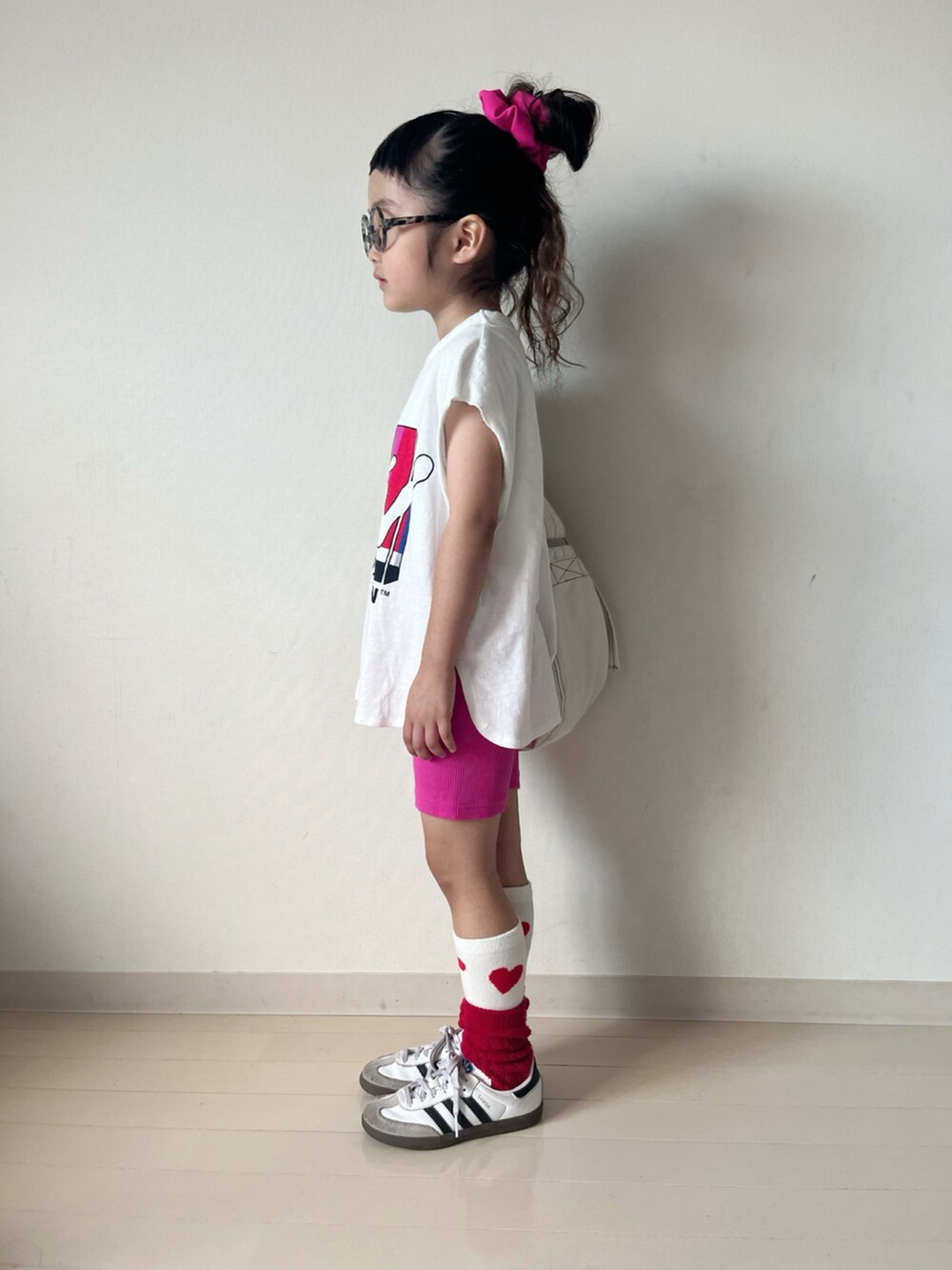 ホワイト系のタンクトップ、ホワイト系のショルダーバッグ、ホワイト系のスニーカーを着用したキッズの夏コーディネートの4枚目の写真