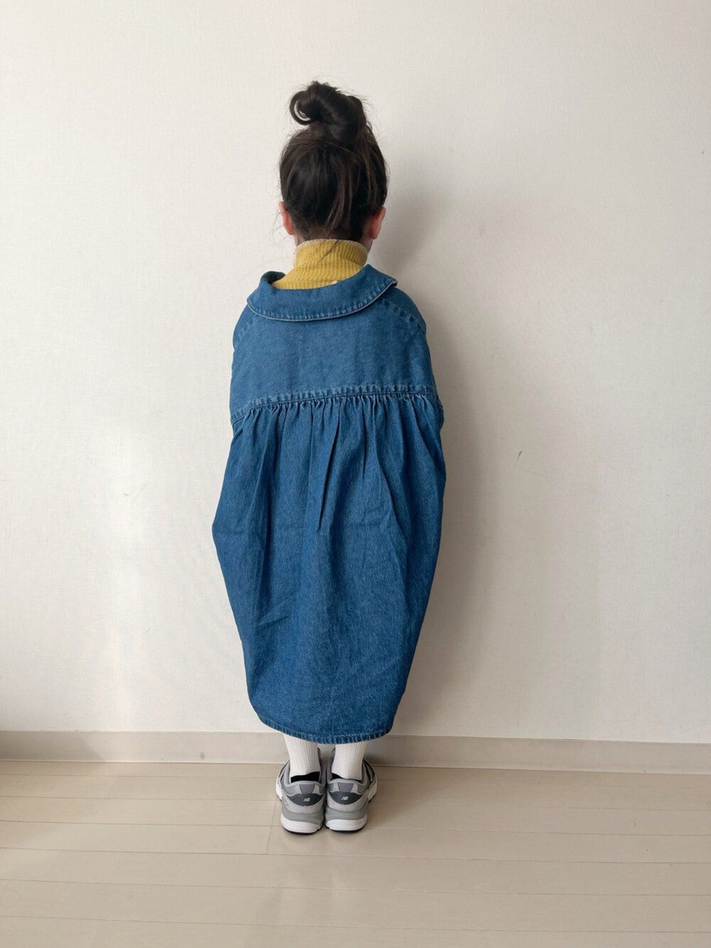 ブルー系のワンピース、イエロー系のTシャツ/カットソー、グレー系のスニーカーを着用したキッズの冬コーディネートの3枚目の写真