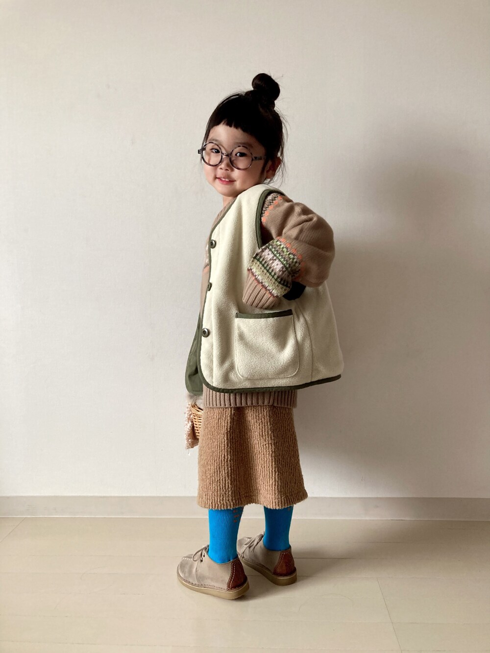 ベージュ系のニット/セーター、グリーン系のベスト、ベージュ系のTシャツ/カットソーを着用したキッズの冬コーディネートの5枚目の写真