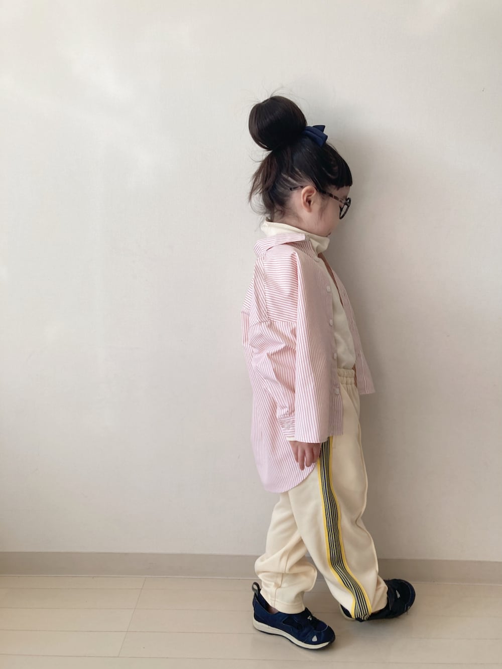 イエロー系のその他パンツ、オレンジ系のシャツ/ブラウス、ホワイト系のTシャツ/カットソーを着用したキッズの冬コーディネートの4枚目の写真