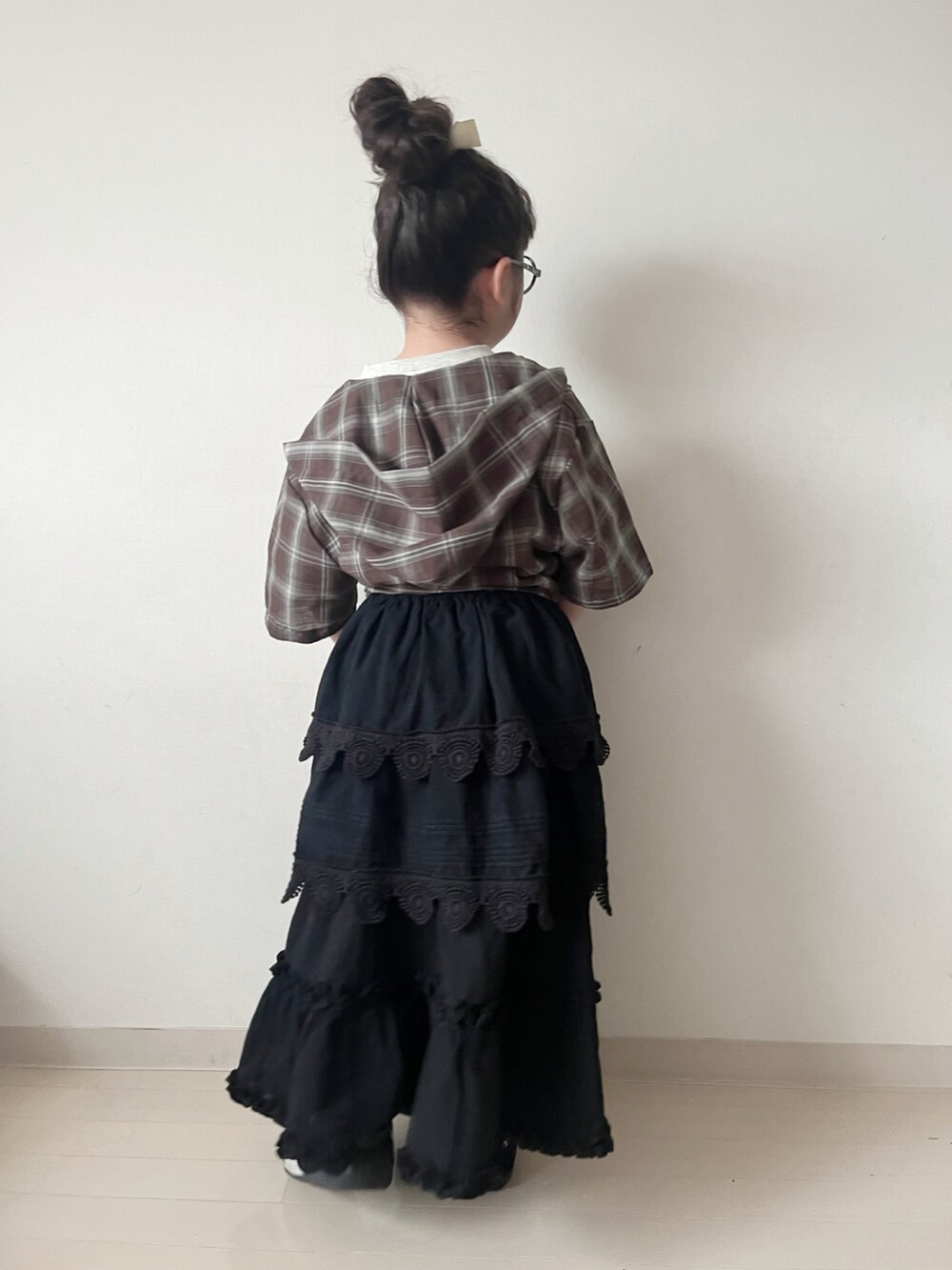 ブラック系のスカート、ブラック系のスカート、ホワイト系のTシャツ/カットソーを着用したキッズの春コーディネートの2枚目の写真