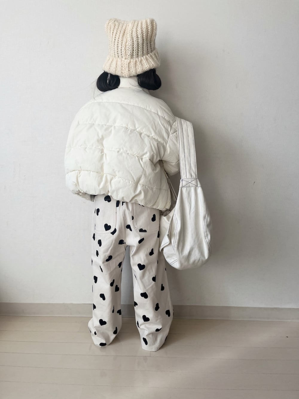 ホワイト系のダウンジャケット/コート、ホワイト系のその他パンツ、ブラック系のニット/セーターを着用したキッズの冬コーディネートの3枚目の写真