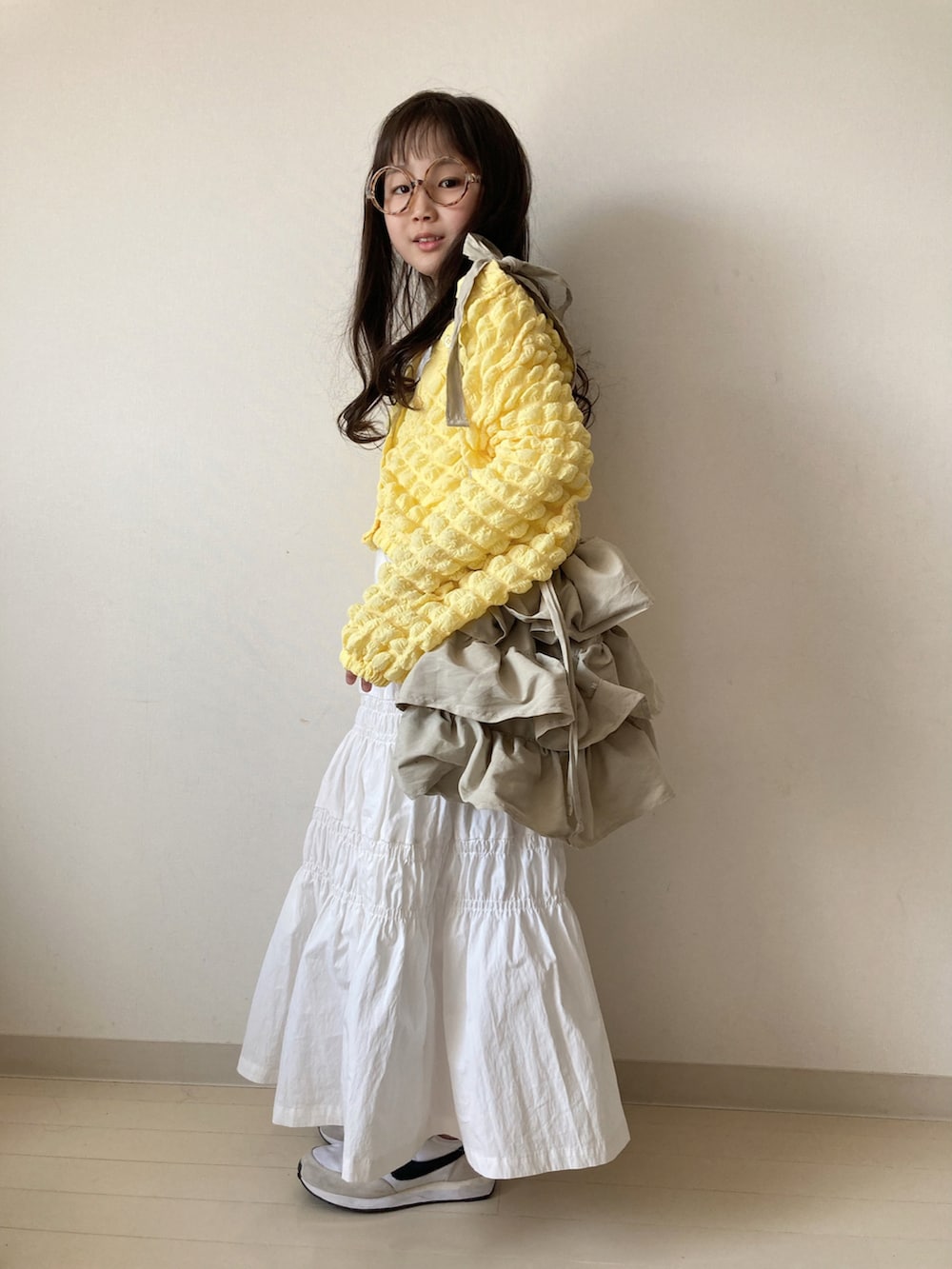 イエロー系のカーディガン/ボレロ、ホワイト系のTシャツ/カットソー、ホワイト系のスカートを着用したキッズの春コーディネートの5枚目の写真