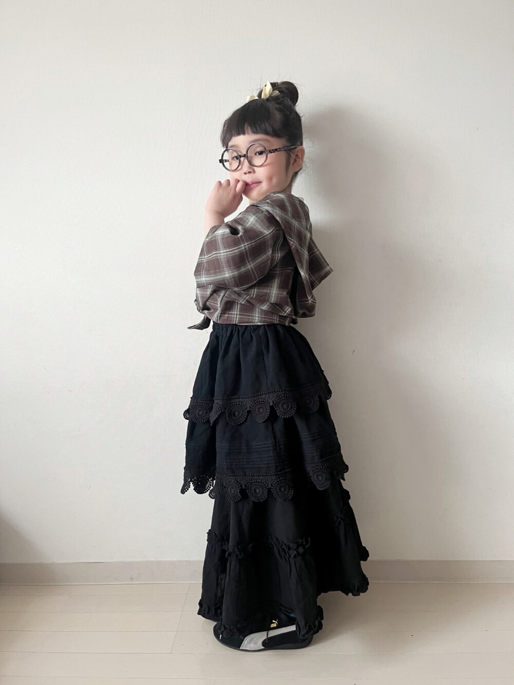 ブラック系のスカート、ブラック系のスカート、ホワイト系のTシャツ/カットソーを着用したキッズの春コーディネートの3枚目の写真
