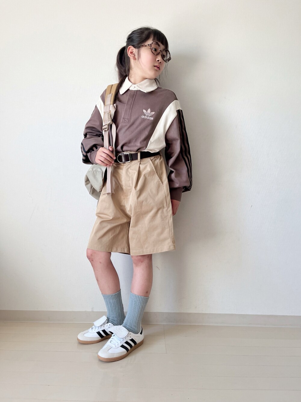 ブラウン系のポロシャツ、ベージュ系のその他パンツ、ベージュ系のバックパック/リュックを着用したキッズの秋コーディネートの3枚目の写真