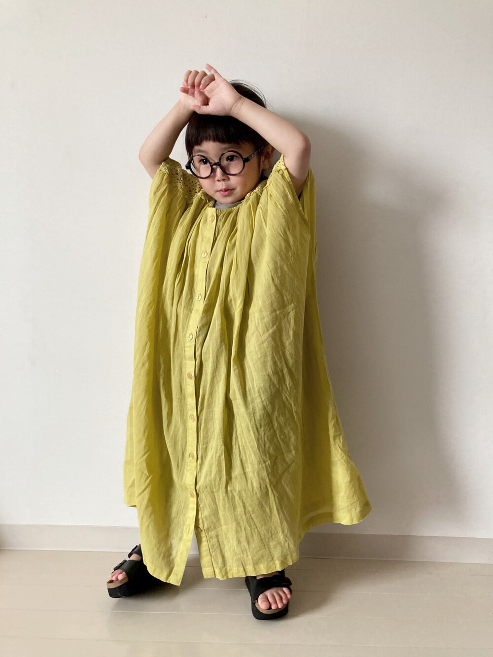 イエロー系のワンピース、グリーン系のTシャツ/カットソー、グリーン系のカーゴパンツを着用したキッズの春コーディネートの5枚目の写真