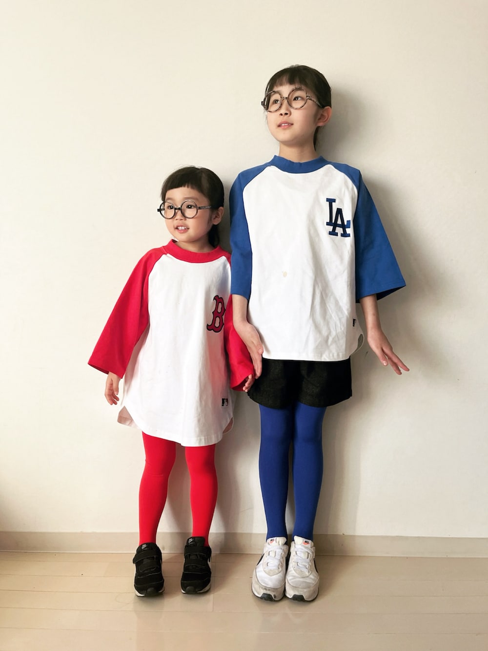 レッド系のTシャツ/カットソー、グリーン系のスカート、ブラック系のデニムパンツを着用したキッズの冬コーディネートの3枚目の写真