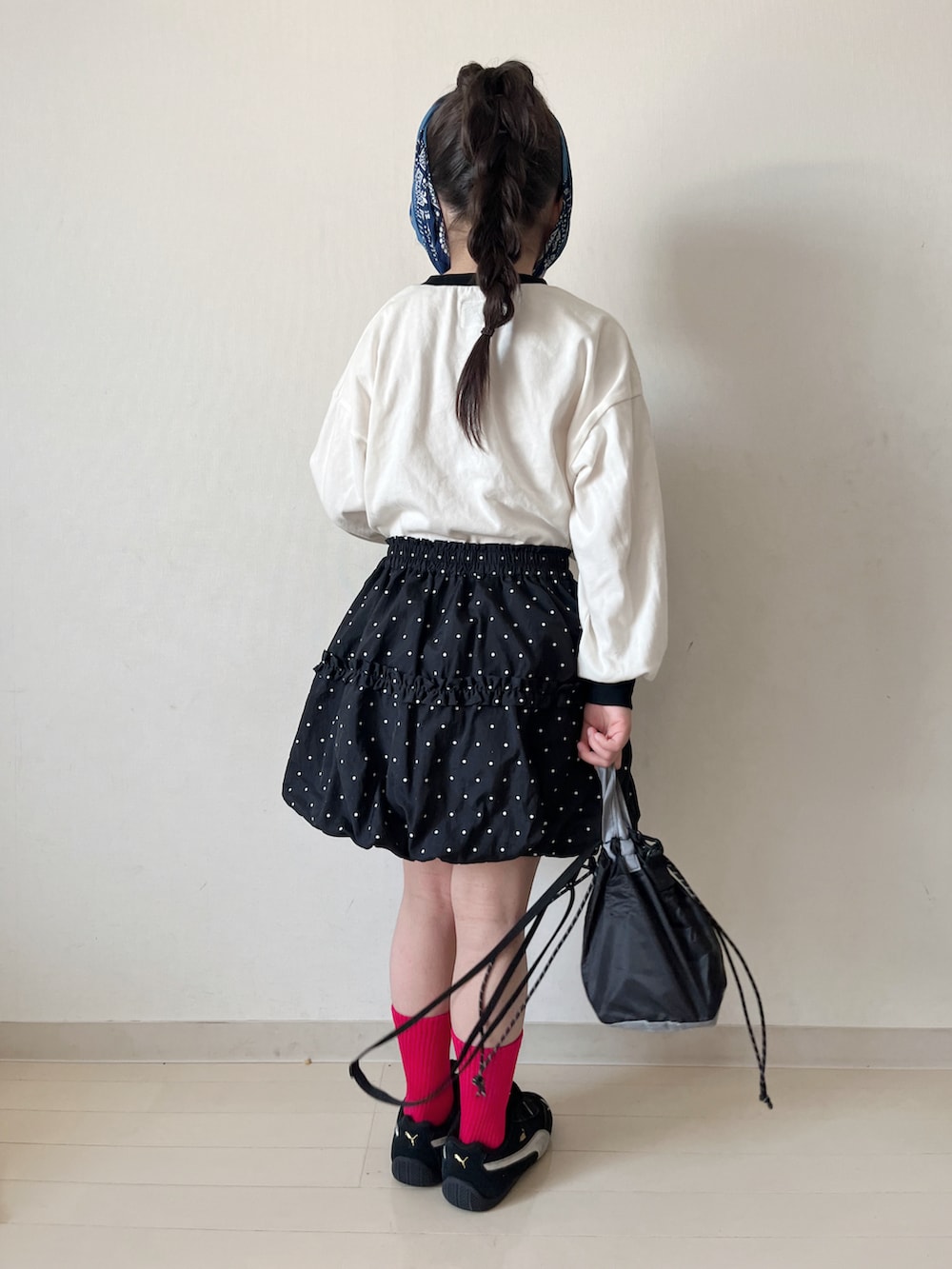 ブラック系のTシャツ/カットソー、ブラック系のスカート、ブラック系のスニーカーを着用したキッズの春コーディネートの2枚目の写真