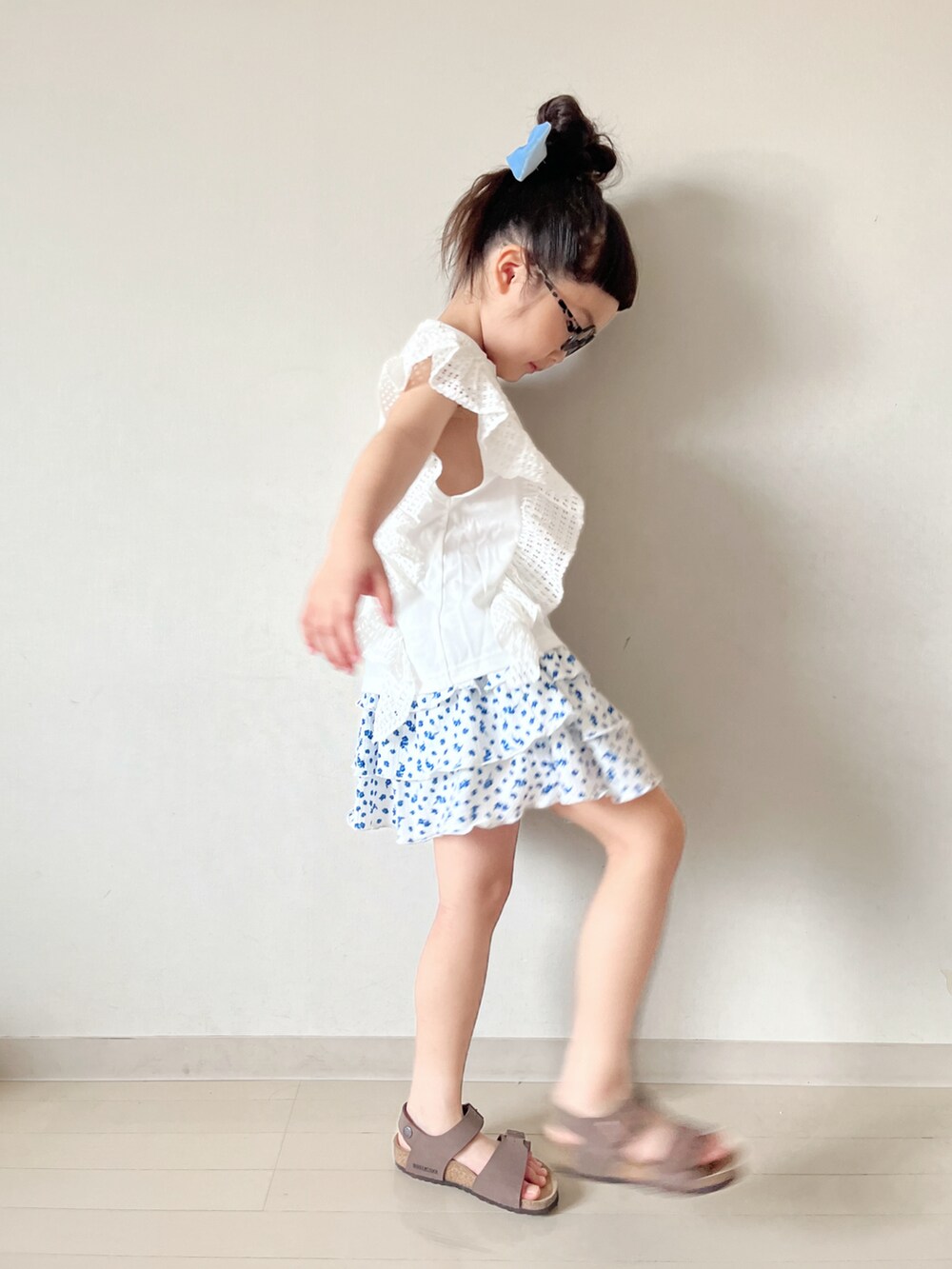 ホワイト系のスカート、ブラウン系のサンダル、ホワイト系のTシャツ/カットソーを着用したキッズの夏コーディネートの2枚目の写真
