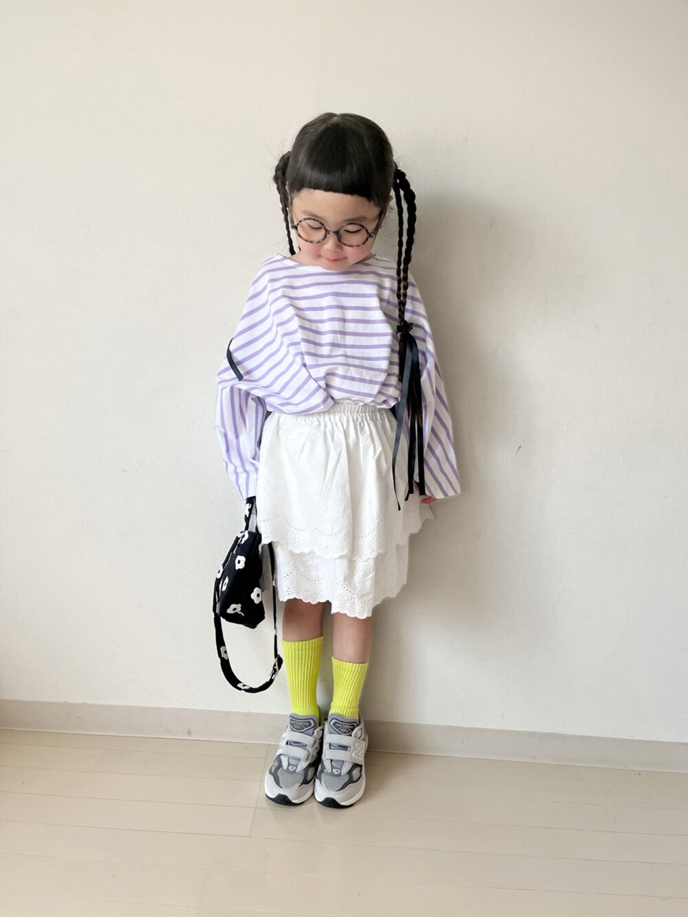 パープル系のTシャツ/カットソー、ホワイト系のスカート、ブラック系のショルダーバッグを着用したキッズの春コーディネートの5枚目の写真