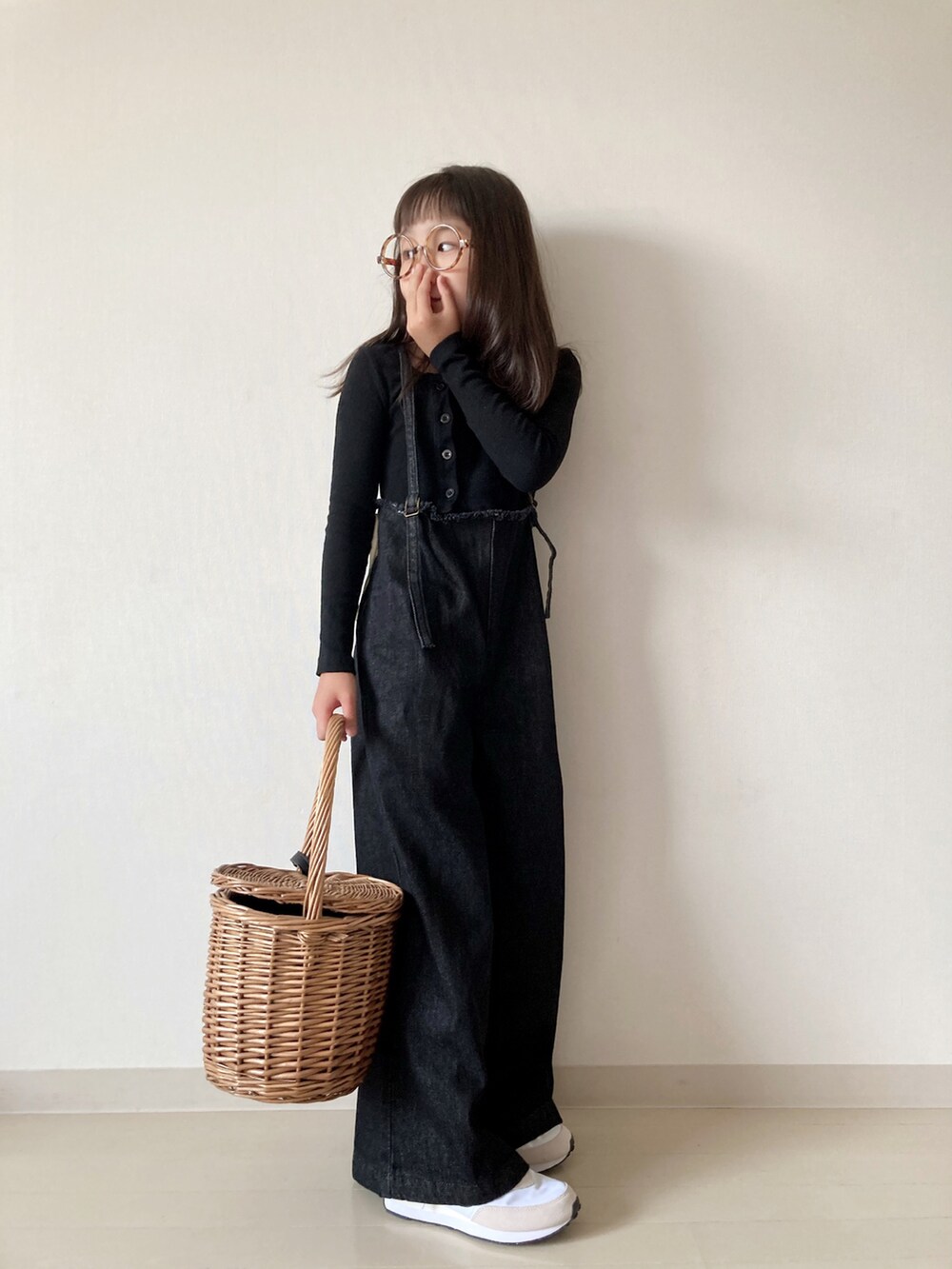 ブラック系のデニムパンツ、ホワイト系のスニーカー、ベージュ系のかごバッグを着用したキッズの夏コーディネートの5枚目の写真