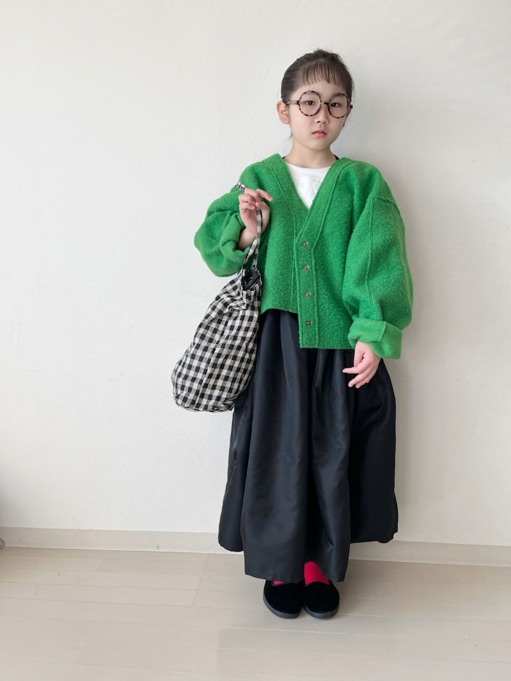 ブラック系のスカート、ブラック系のバッグ、レッド系のタイツ/ストッキングを着用したキッズの冬コーディネートの2枚目の写真
