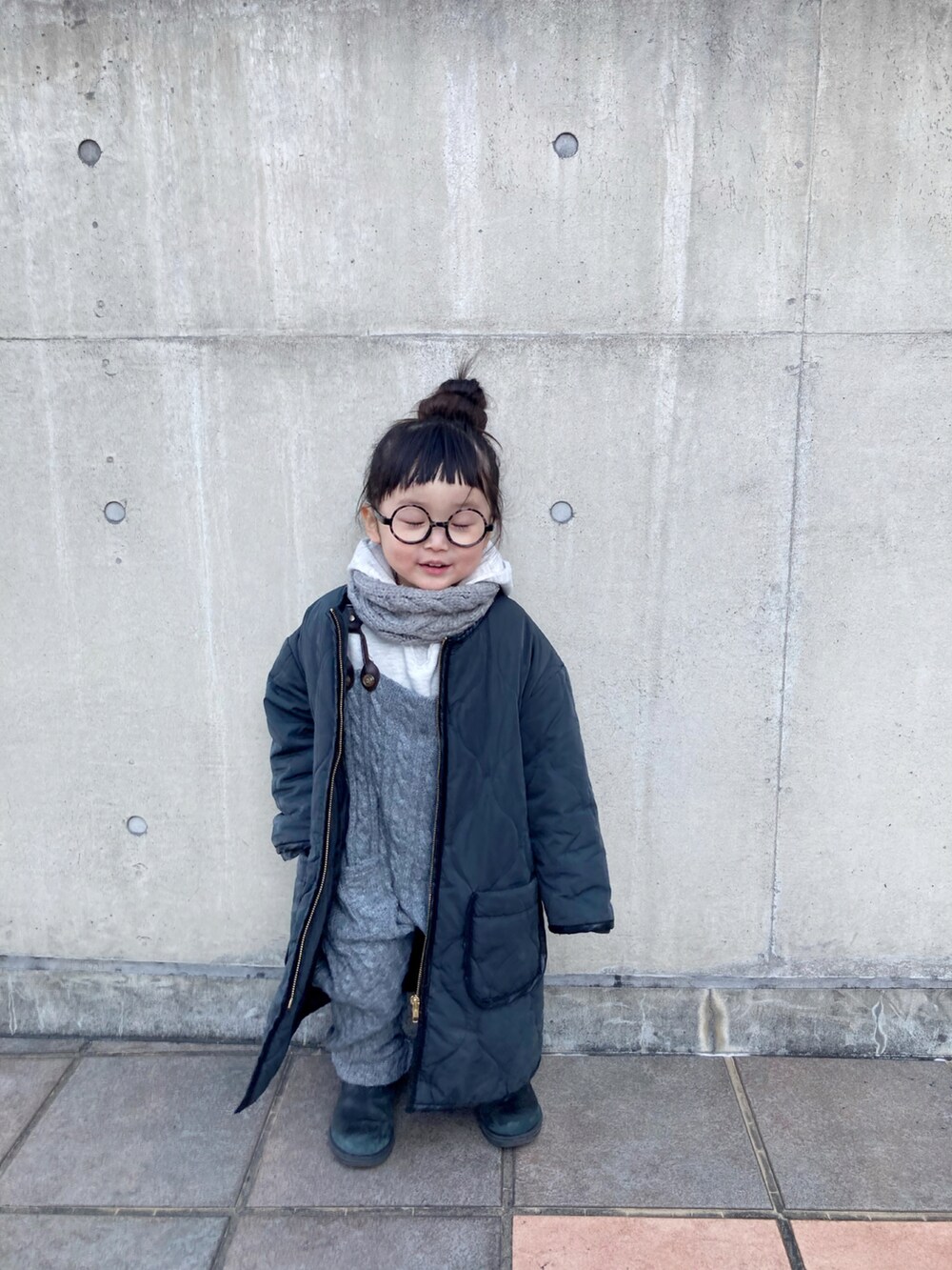 レッド系のブーツ、グレー系のサロペット/オーバーオール、ブラック系のニット/セーターを着用したキッズの冬コーディネートの3枚目の写真