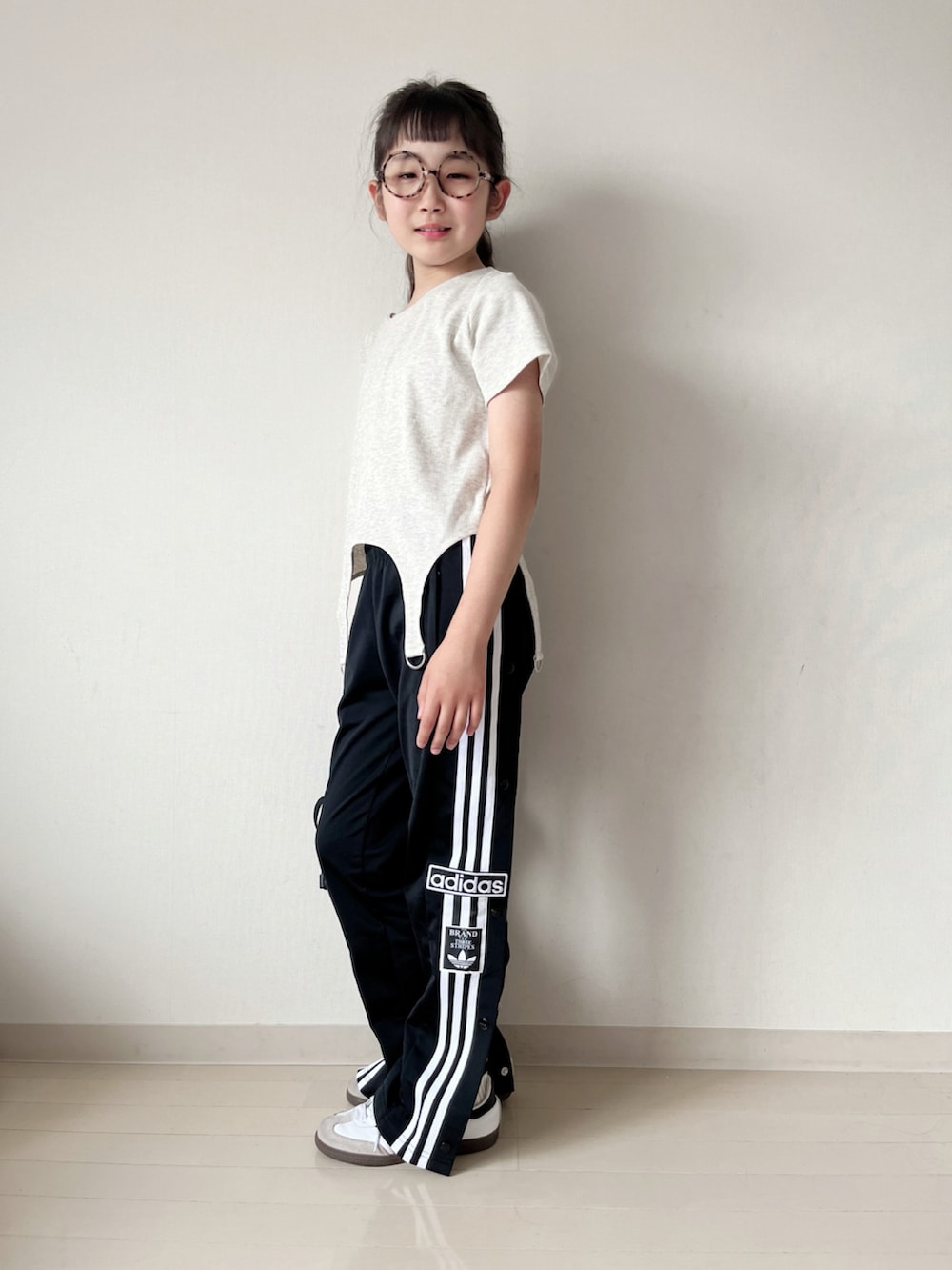 ベージュ系のTシャツ/カットソー、ブラック系のその他パンツ、ホワイト系のスニーカーを着用したキッズの夏コーディネートの3枚目の写真