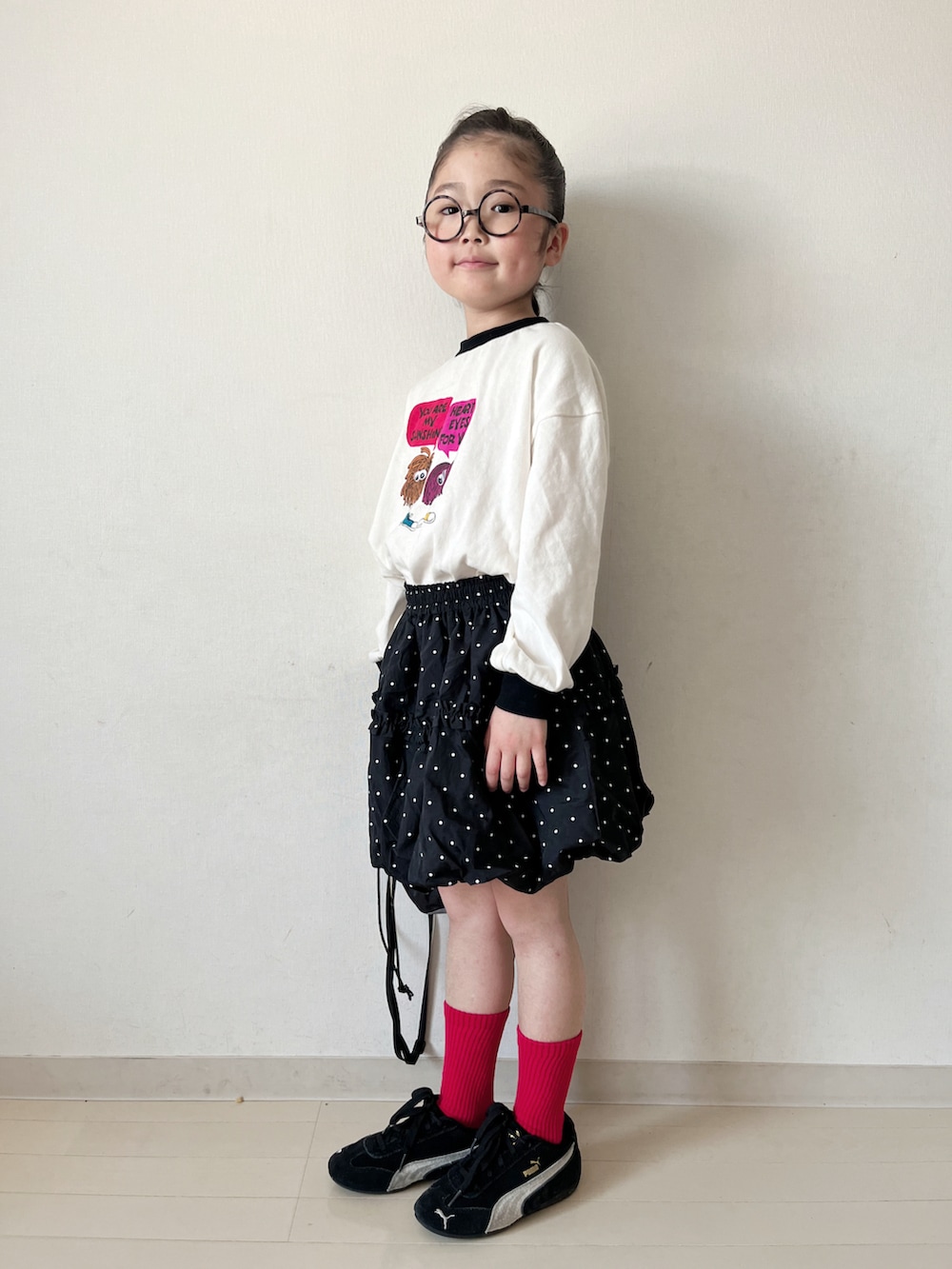ブラック系のTシャツ/カットソー、ブラック系のスカート、ブラック系のスニーカーを着用したキッズの春コーディネートの4枚目の写真