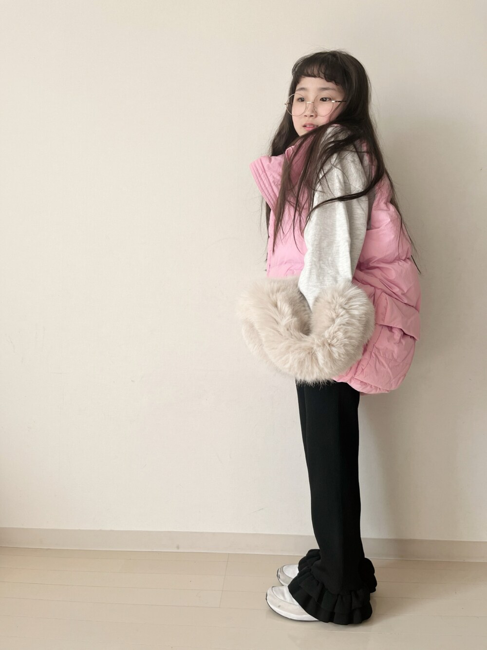 ブラック系のその他パンツ、ピンク系のダウンベスト、ベージュ系のスウェットを着用したキッズの冬コーディネートの4枚目の写真