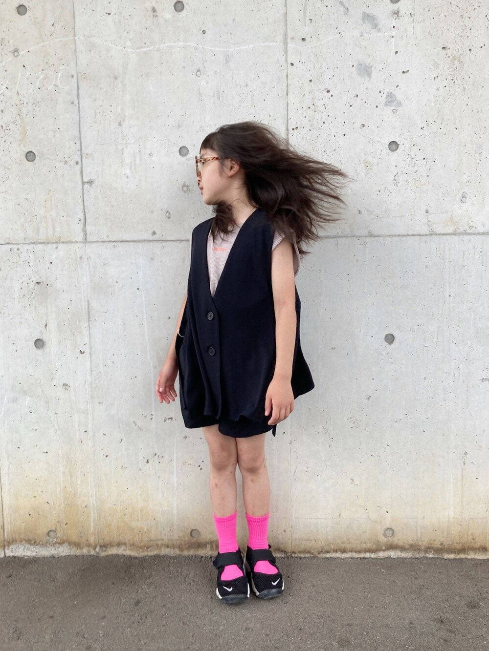 グレー系のタンクトップ、グレー系のベスト、ブラック系のスニーカーを着用したキッズの秋コーディネートの2枚目の写真