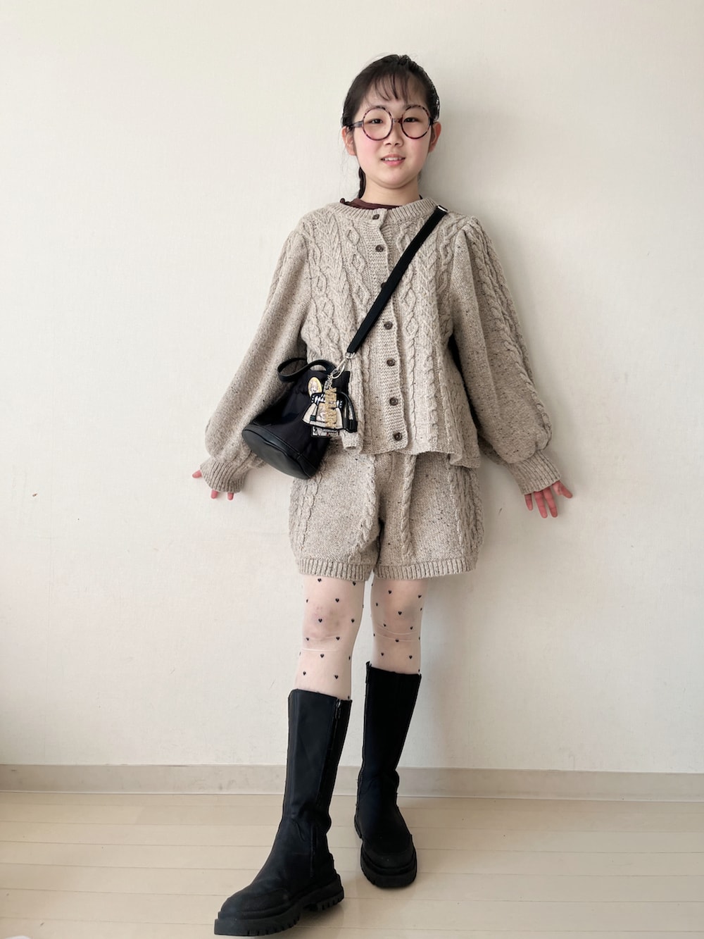 ベージュ系のその他パンツ、ベージュ系のニット/セーター、ブラウン系のTシャツ/カットソーを着用したキッズの冬コーディネートの2枚目の写真