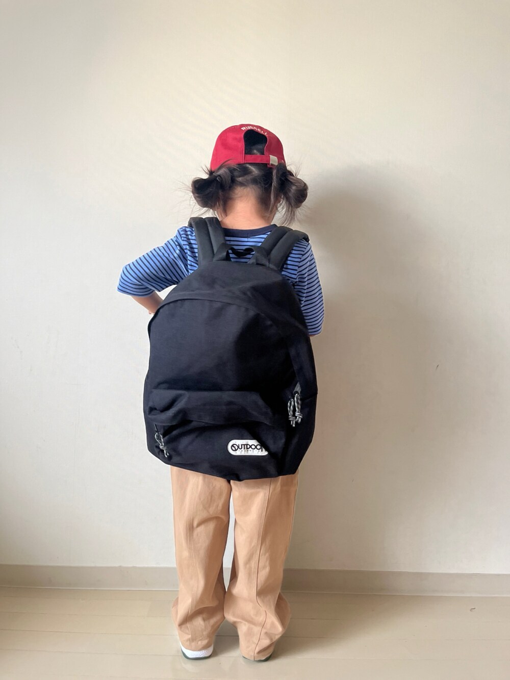 ブルー系のTシャツ/カットソー、ベージュ系のその他パンツ、ブラック系のバックパック/リュックを着用したキッズの秋コーディネートの4枚目の写真