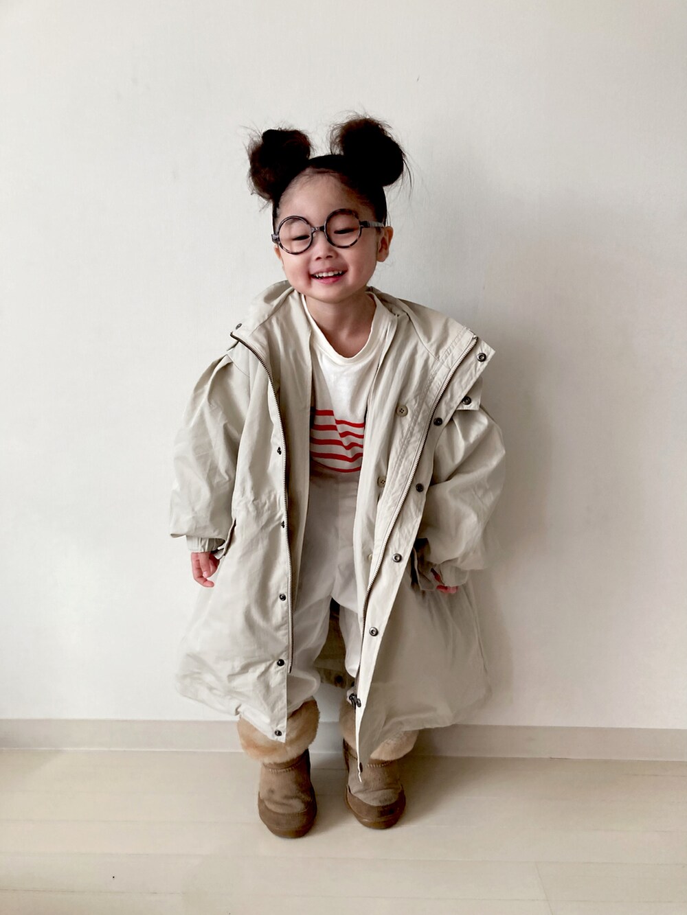 ベージュ系のモッズコート、ホワイト系のベスト、ホワイト系のその他パンツを着用したキッズの冬コーディネートの4枚目の写真