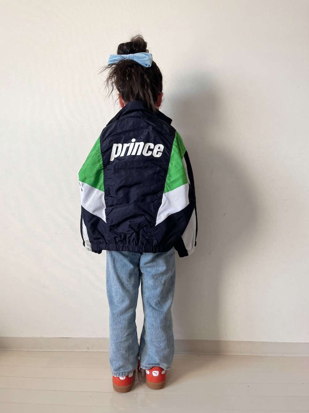 レッド系のカーディガン/ボレロ、ブルー系のブルゾン、ブルー系のオールインワン・サロペットを着用したキッズの春コーディネートの2枚目の写真