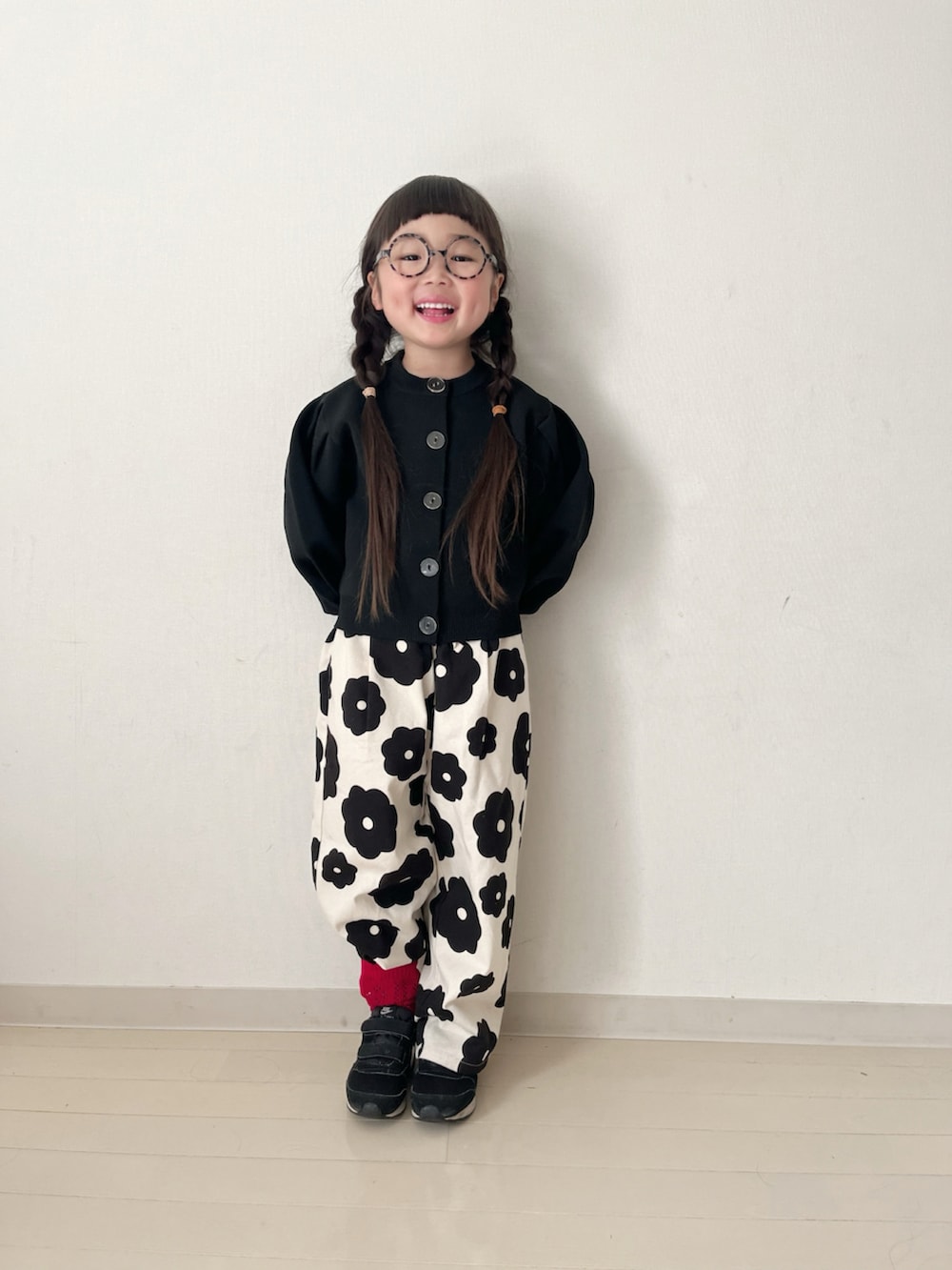 ホワイト系のその他パンツ、ブラック系のカーディガン/ボレロ、ブラック系のスニーカーを着用したキッズの冬コーディネートの2枚目の写真