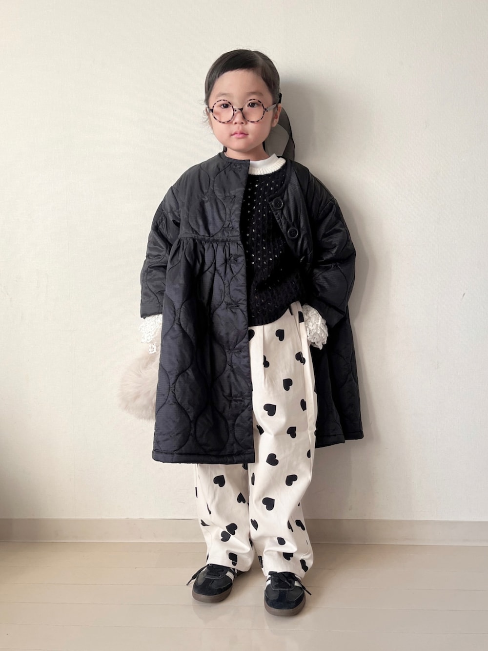 ブラック系のミリタリージャケット、ブラック系のニット/セーター、ホワイト系のTシャツ/カットソーを着用したキッズの秋コーディネートの4枚目の写真