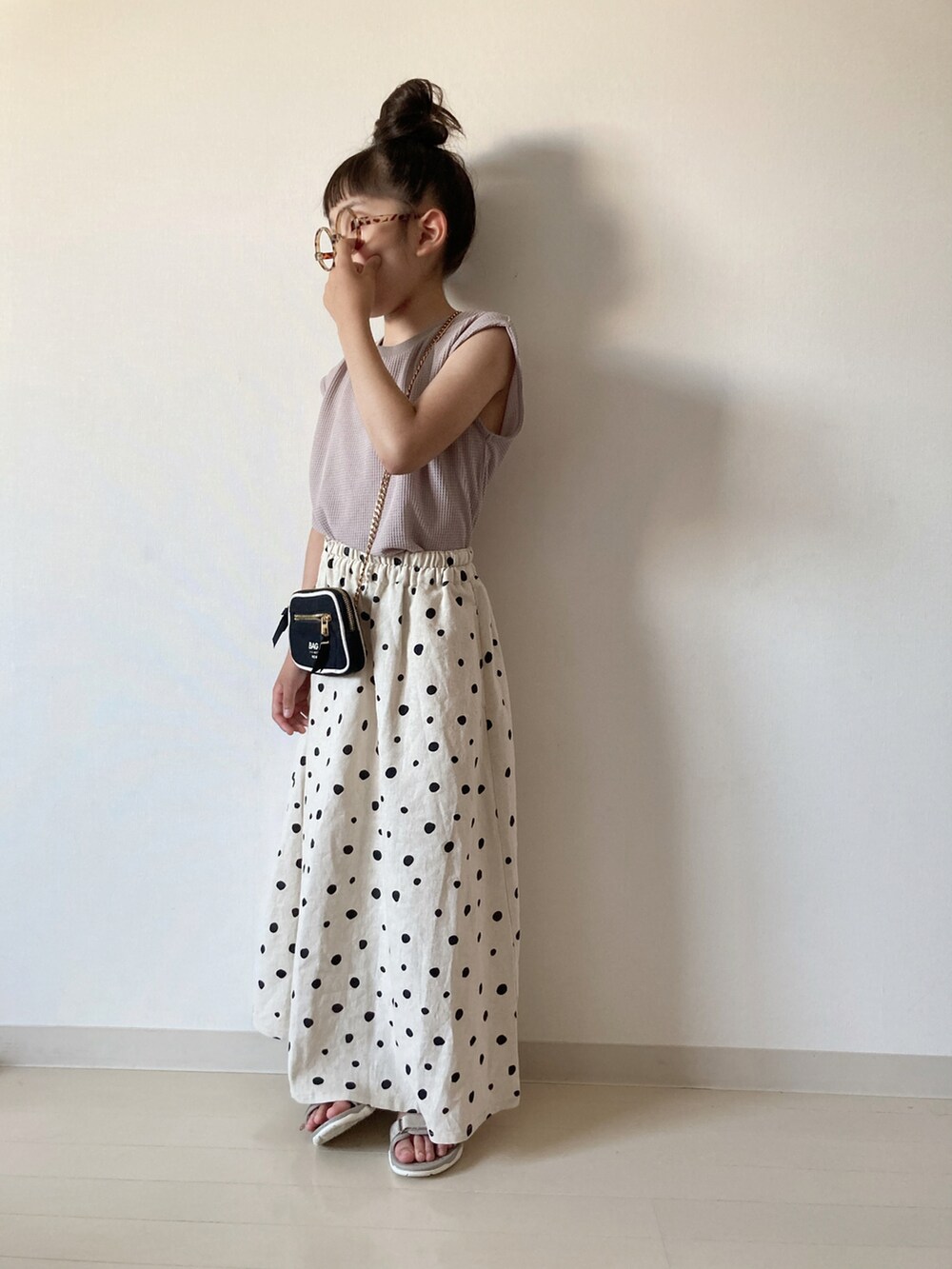 ホワイト系のスカート、グレー系のタンクトップ、ベージュ系のサンダルを着用したキッズの夏コーディネートの2枚目の写真
