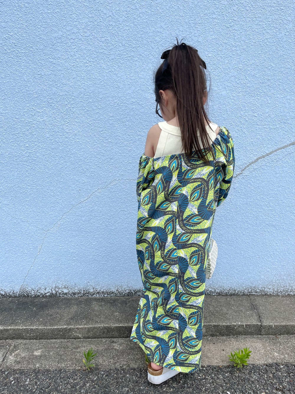 イエロー系のワンピース、ホワイト系のタンクトップ、グリーン系のカーディガン/ボレロを着用したキッズの春コーディネートの5枚目の写真