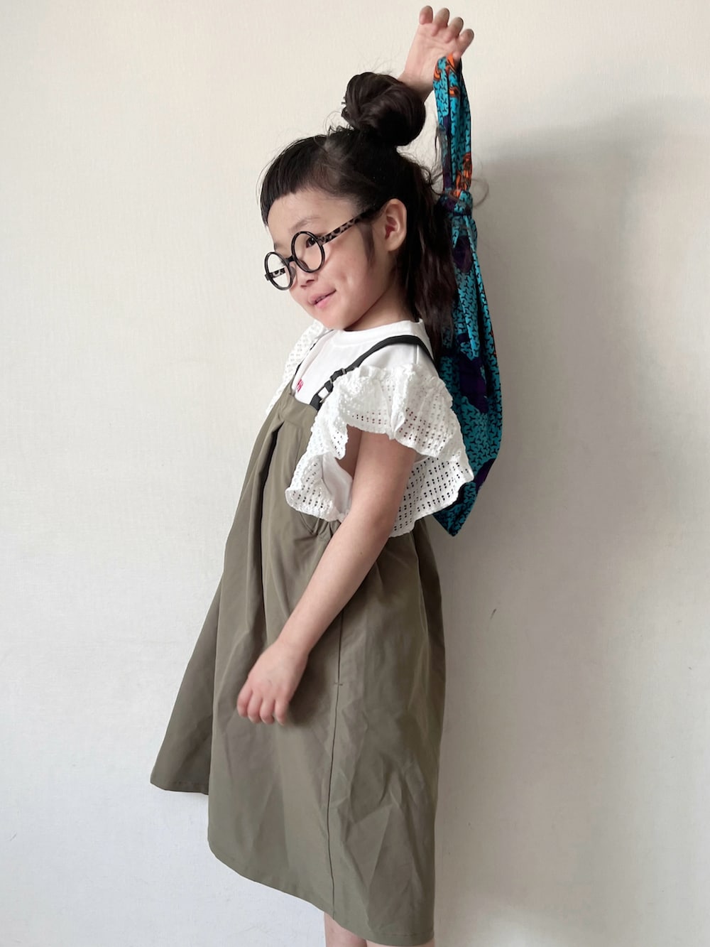 グリーン系のワンピース、ブルー系のハンドバッグ、グリーン系のサンダルを着用したキッズの夏コーディネートの4枚目の写真