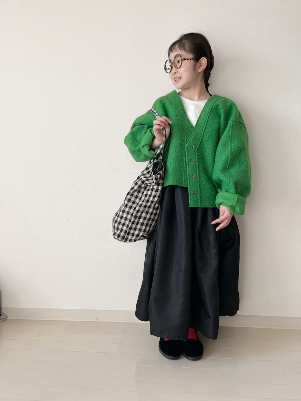 ブラック系のスカート、ブラック系のバッグ、レッド系のタイツ/ストッキングを着用したキッズの冬コーディネートの4枚目の写真