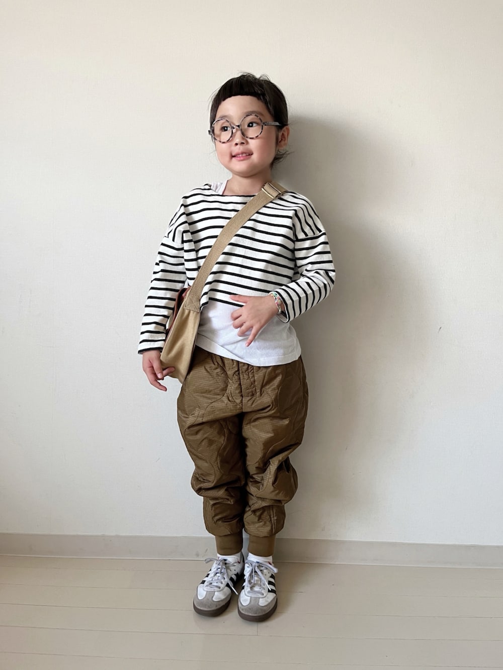 ブラウン系のダウンジャケット/コート、ブラウン系のその他パンツ、ブラック系のTシャツ/カットソーを着用したキッズの秋コーディネートの2枚目の写真