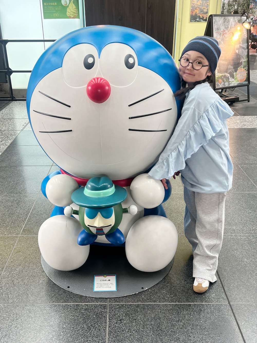 ブルー系のワンピース、グレー系のスウェットパンツ、ホワイト系のスニーカーを着用したキッズの春コーディネートの3枚目の写真