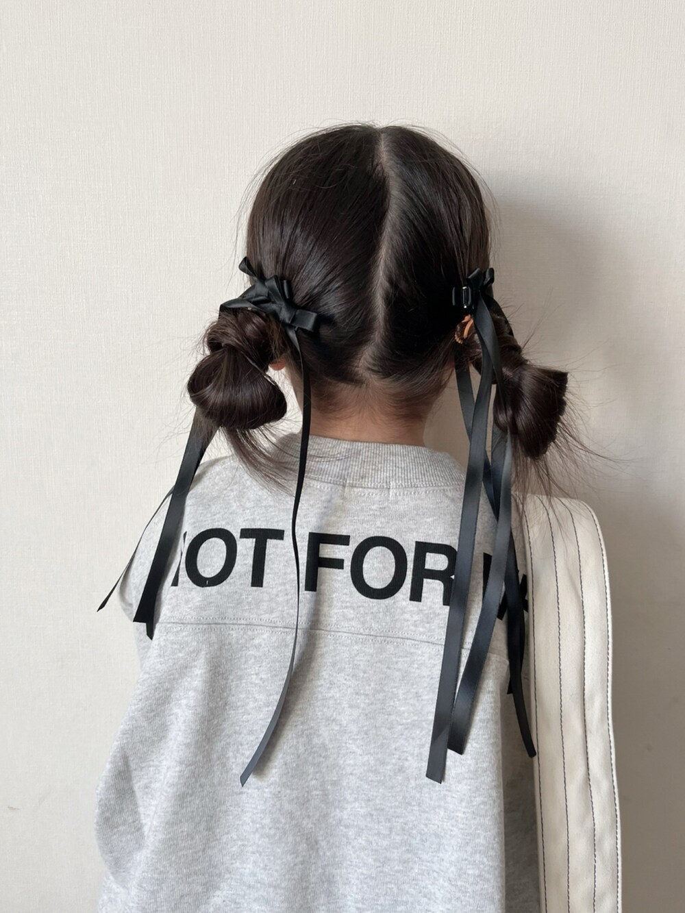 ホワイト系のワンピース、ブラック系のスカート、ブラック系のスニーカーを着用したキッズの冬コーディネートの5枚目の写真